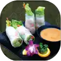 Spring rolls with dipping sauce and garnish.
