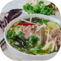 Bowl of Vietnamese pho with herbs.