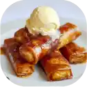 Caramelized dessert rolls with ice cream topping.