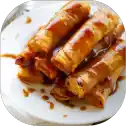 Golden spring rolls drizzled with sweet sauce.